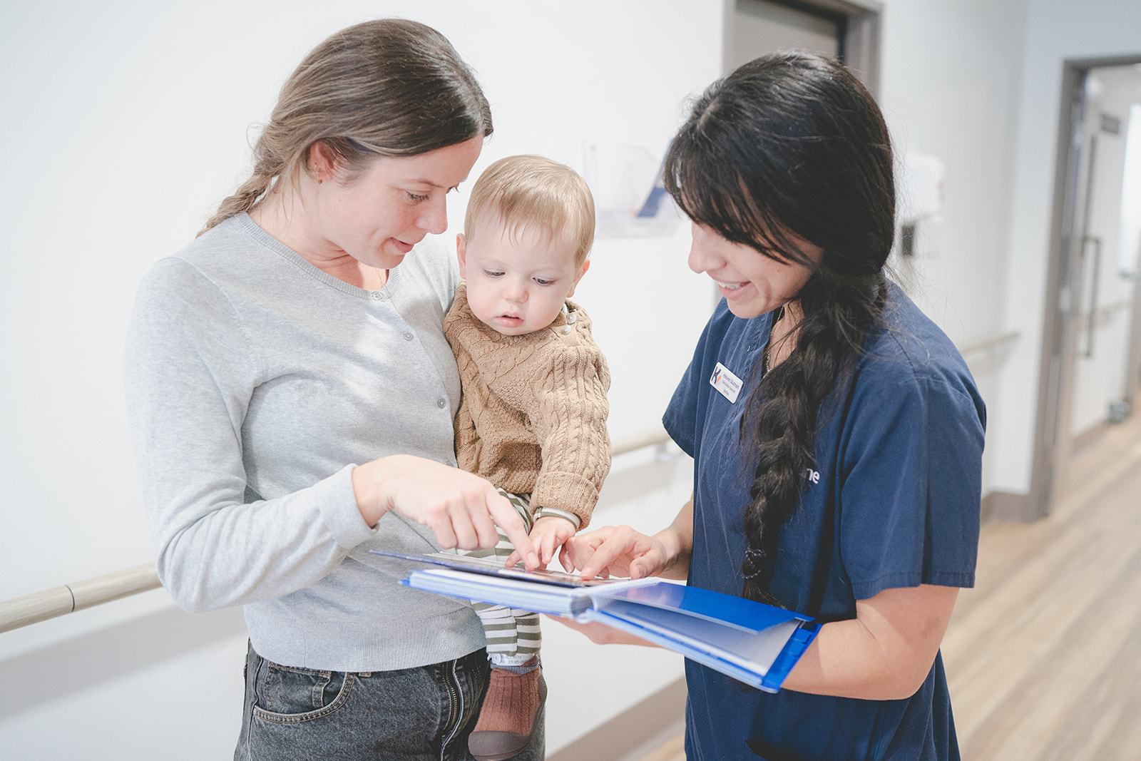 A Karitane Nurse offering advice to a mother and her baby