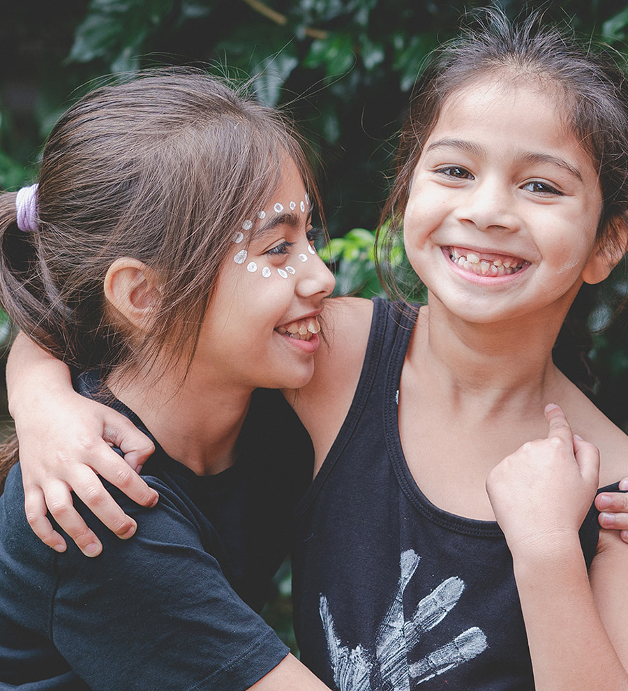 Two children smiling and hugging